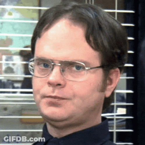 A Man Wearing Glasses And A Blue Shirt Is Making A Funny Face GIF