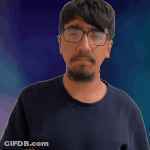 A Man Wearing Glasses And A Blue Shirt Is Pointing Up GIF