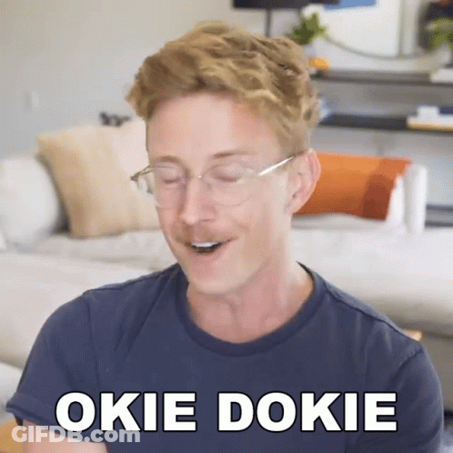 A Man Wearing Glasses And A Blue Shirt Says " Okie Dokie " In White Letters GIF