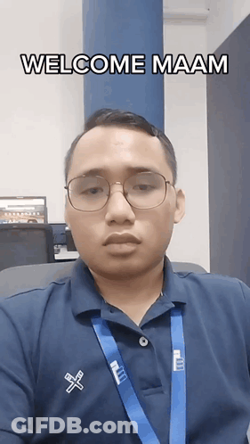 A Man Wearing Glasses And A Blue Shirt That Says Welcome Maam On It GIF