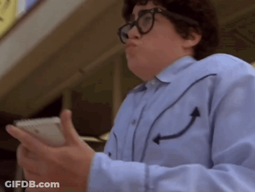 A Man Wearing Glasses And A Blue Shirt With Arrows On The Sleeves Is Holding A Cell Phone GIF