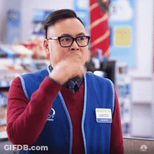 A Man Wearing Glasses And A Blue Vest Has A Name Tag That Says Mateo GIF