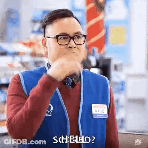 A Man Wearing Glasses And A Blue Vest Is Making A Funny Face And Saying Scheld ? GIF