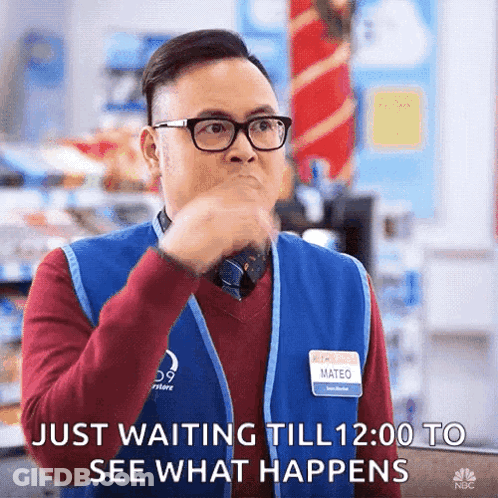 A Man Wearing Glasses And A Blue Vest Is Waiting To See What Happens GIF