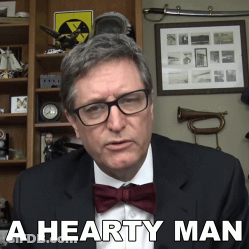 A Man Wearing Glasses And A Bow Tie Has The Words A Hearty Man Below Him GIF