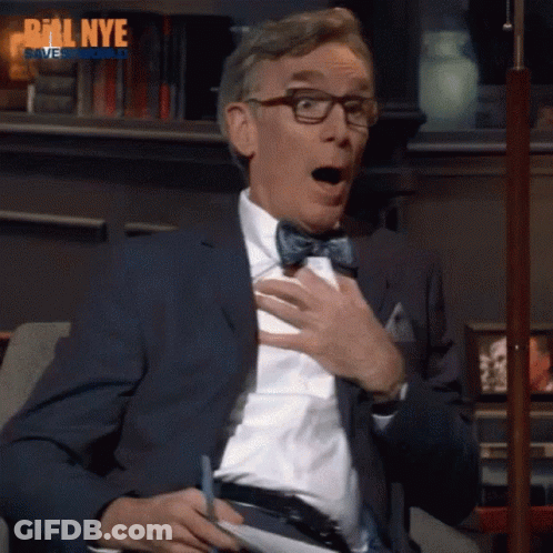 A Man Wearing Glasses And A Bow Tie Is Sitting On A Couch With His Mouth Open And The Words Bill Nye Behind Him GIF