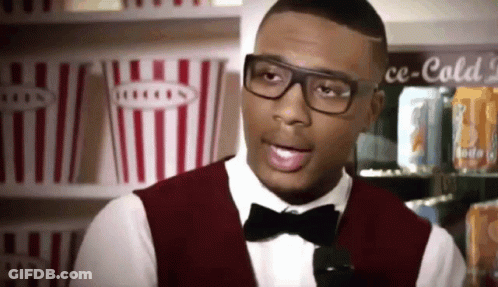 A Man Wearing Glasses And A Bow Tie Stands In Front Of A Cooler That Says Ce-Cold GIF