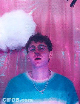 A Man Wearing Glasses And A Chain With The Letter P On It GIF