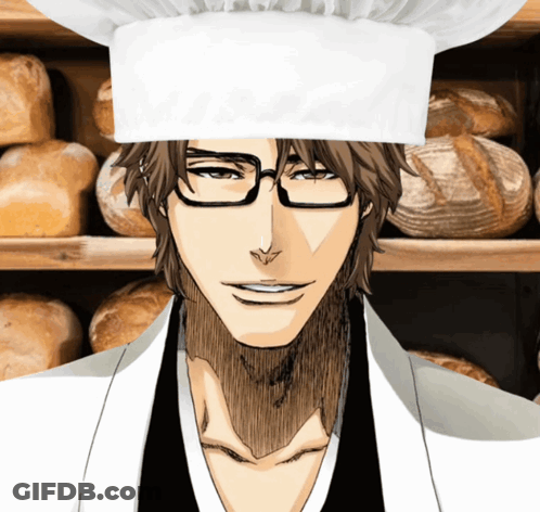 A Man Wearing Glasses And A Chef 'S Hat Is Smiling In Front Of A Shelf Of Bread GIF