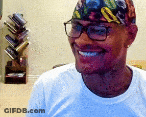 A Man Wearing Glasses And A Colorful Headband Smiles GIF