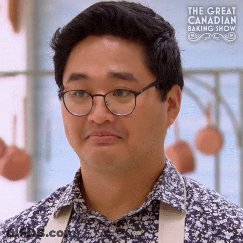 A Man Wearing Glasses And A Floral Shirt Is On A Tv Show Called The Great Canadian Baking Show GIF