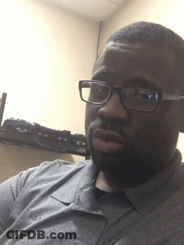A Man Wearing Glasses And A Gray Shirt GIF