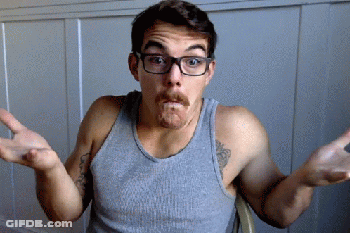 A Man Wearing Glasses And A Gray Tank Top Makes A Funny Face GIF