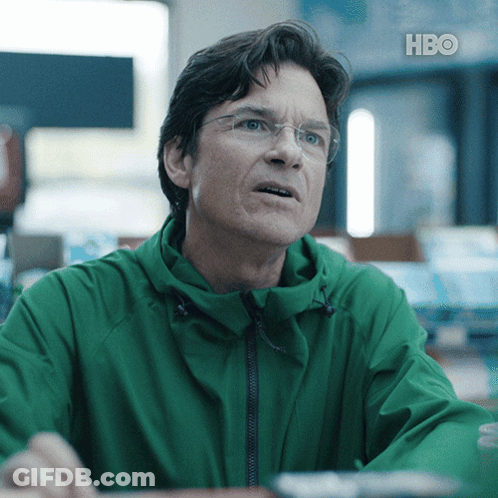 A Man Wearing Glasses And A Green Jacket With Hbo Written On The Bottom Right GIF
