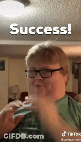 A Man Wearing Glasses And A Green Shirt Is Making A Funny Face And The Caption Says Success GIF
