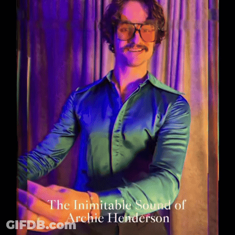 A Man Wearing Glasses And A Green Shirt With The Words The Inimitable Sound Of Archie Henderson On The Bottom GIF