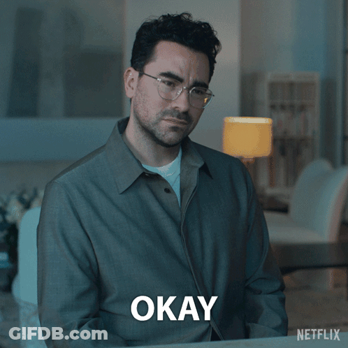 A Man Wearing Glasses And A Grey Shirt Says Okay GIF