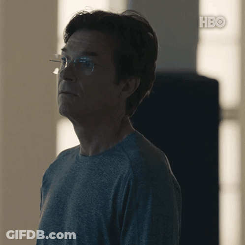 A Man Wearing Glasses And A Grey Shirt With Hbo On The Bottom Right GIF