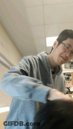 A Man Wearing Glasses And A Grey Sweatshirt Has A Name Tag That Says ' Chris ' GIF