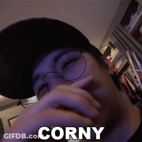 A Man Wearing Glasses And A Hat Is Covering His Mouth With His Hand And The Word Corny Is Visible . GIF