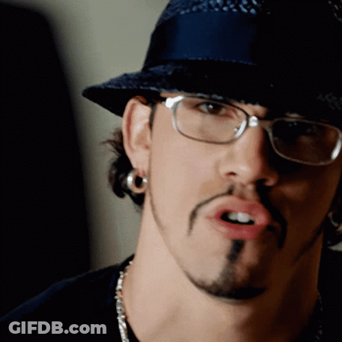 A Man Wearing Glasses And A Hat Is Making A Face GIF