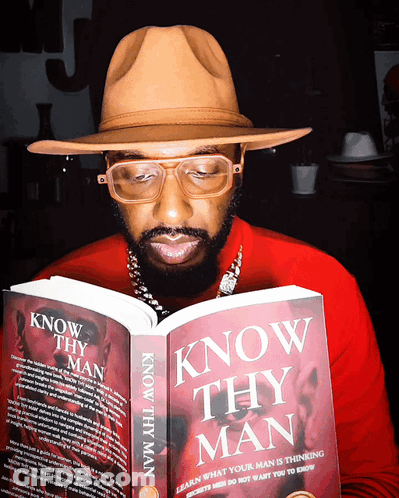A Man Wearing Glasses And A Hat Is Reading A Book Titled Know Thy Man GIF
