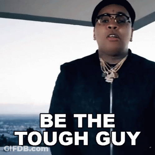 A Man Wearing Glasses And A Hat Is Saying Be The Tough Guy GIF