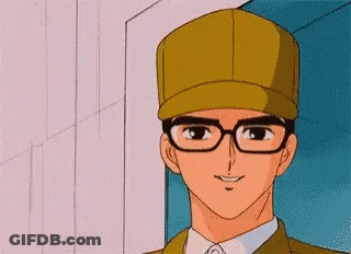 A Man Wearing Glasses And A Hat Is Smiling For The Camera GIF