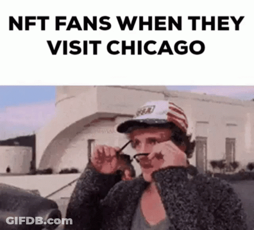 A Man Wearing Glasses And A Hat Is Standing In Front Of A Building And Looking At His Glasses . GIF