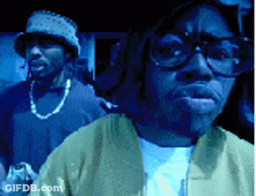 Man With Glasses And Hat Standing Next To Another Man GIF