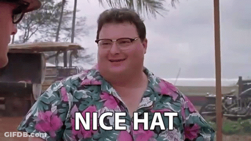 A Man Wearing Glasses And A Hawaiian Shirt Is Standing Next To Another Man And Saying `` Nice Hat '' . GIF