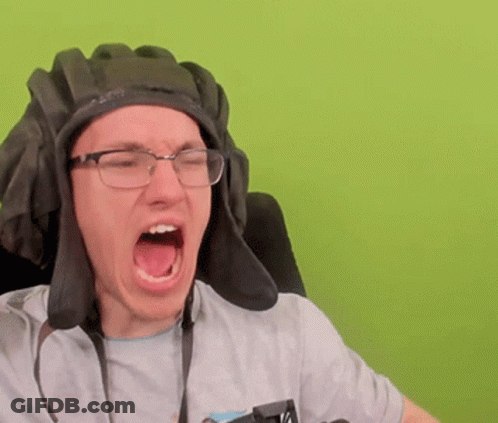 A Man Wearing Glasses And A Helmet Is Screaming With His Mouth Open GIF