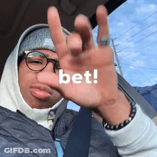 A Man Wearing Glasses And A Hoodie Holds Up His Hand With The Word Bet Written On It GIF