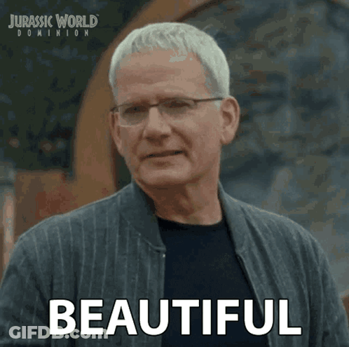 A Man Wearing Glasses And A Jacket Says Beautiful In A Jurassic World Dominion Advertisement GIF