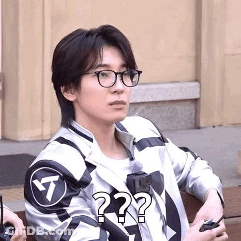 A Man Wearing Glasses And A Jacket With A Question Mark GIF