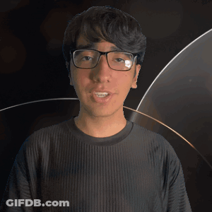 A Man Wearing Glasses And A Kane Shirt Looks At The Camera GIF
