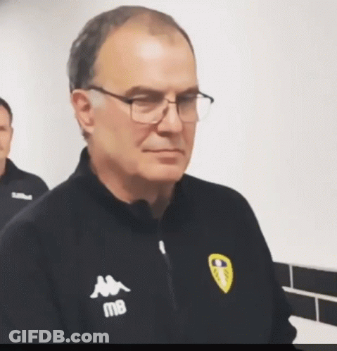 A Man Wearing Glasses And A Kappa Jacket Looks At The Camera GIF
