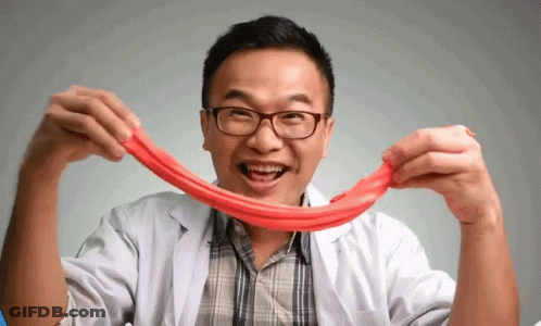 A Man Wearing Glasses And A Lab Coat Is Holding A Red String GIF