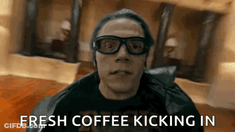 A Man Wearing Glasses And A Leather Jacket Is Holding A Cup Of Coffee . GIF