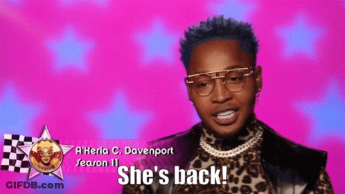 A Man Wearing Glasses And A Leopard Print Shirt Says She 'S Back GIF