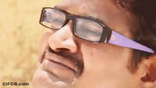 A Man Wearing Glasses And A Mustache Is Making A Face . GIF