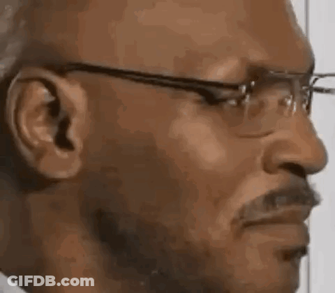 A Man Wearing Glasses And A Mustache Is Making A Funny Face . GIF