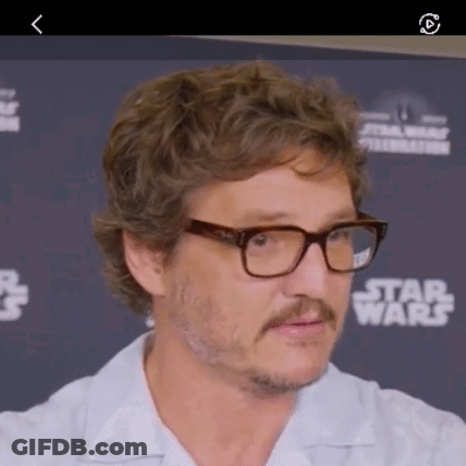 A Man Wearing Glasses And A Mustache Is Standing In Front Of A Star Wars Sign . GIF