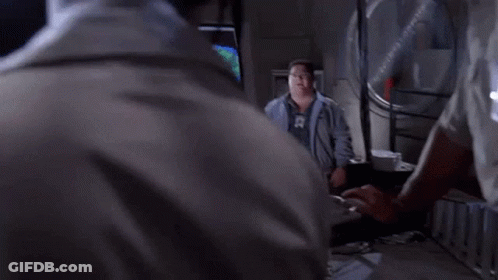 A Man Wearing Glasses And A Name Tag That Says ' Smith ' On It Is Making A Funny Face . GIF