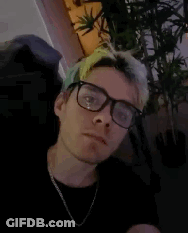 A Man Wearing Glasses And A Necklace Has The Words I Have A Bomb Written On His Face GIF