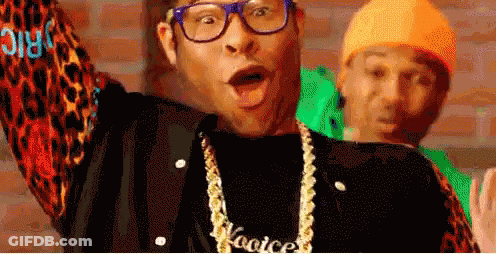 A Man Wearing Glasses And A Necklace With The Word Kooice On It . GIF