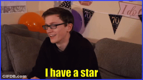A Man Wearing Glasses And A Party Hat Is Sitting On A Couch And Says I Have A Star GIF