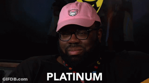 A Man Wearing Glasses And A Pink Hat With The Word Platinum On It GIF