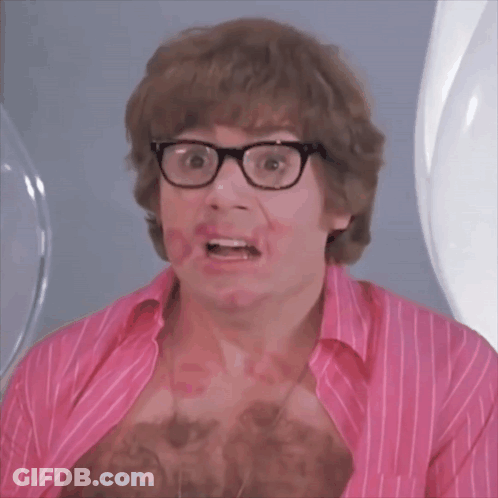 A Man Wearing Glasses And A Pink Shirt Has Red Lipstick On His Chest GIF