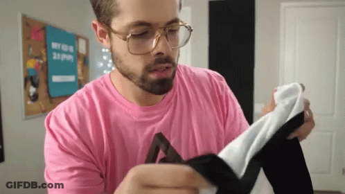 Man In Glasses And Pink Shirt Holding Fabric GIF